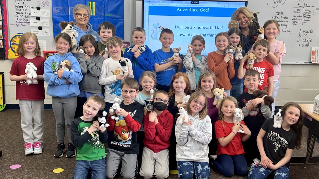 Children in classroom holding TwoByTwo boxes that have stuffed animals inside