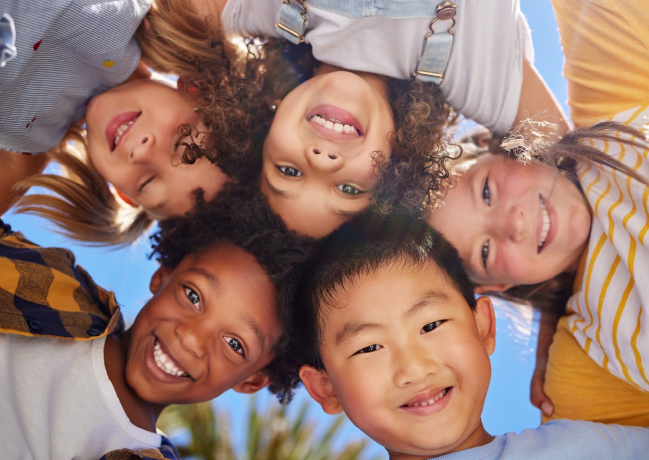 Children looking down at the camera, smiling.